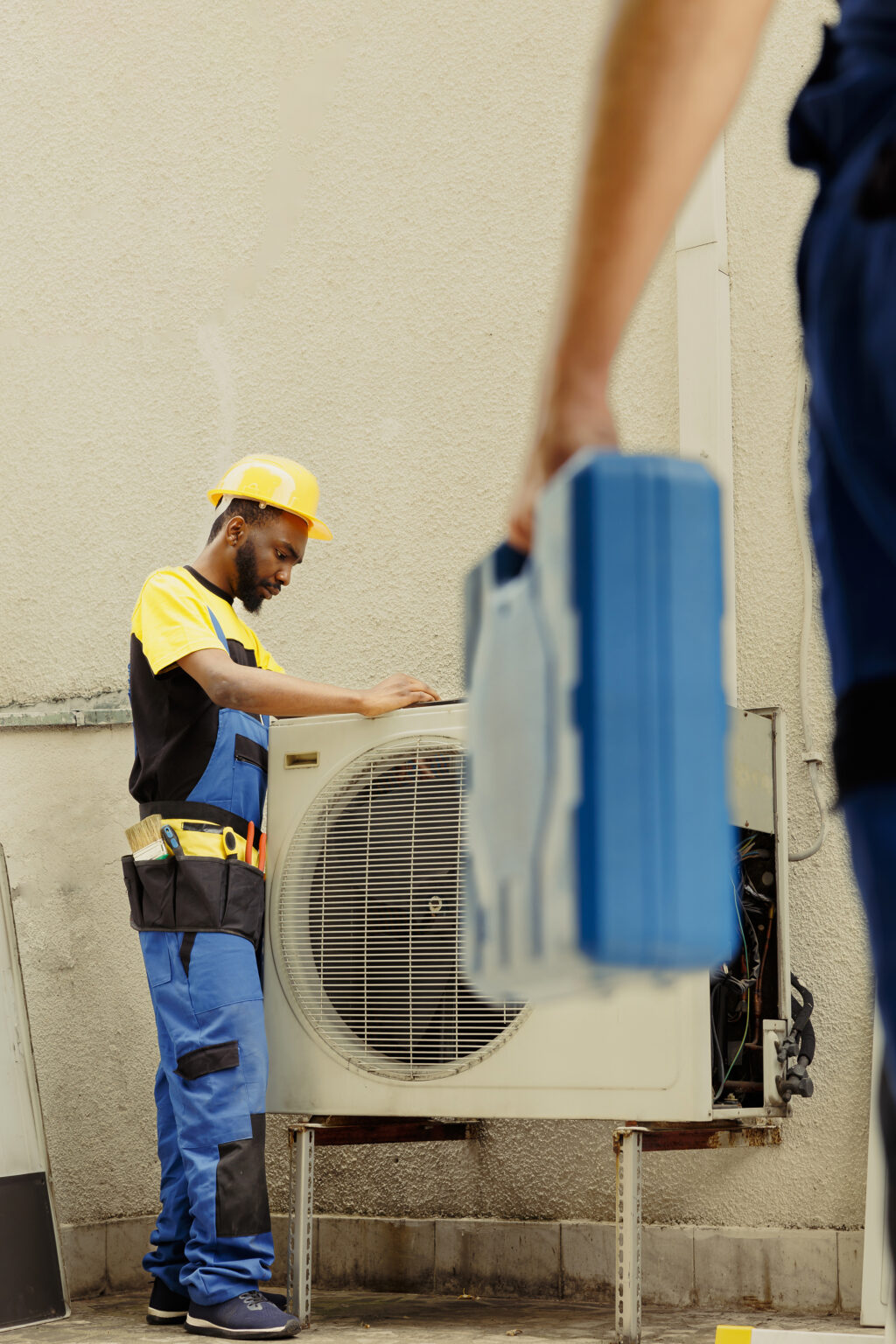 Master serviceman arriving on location to help apprentice worker fix unfunctional compressor in faulty hvac system. Experts coworkers contracted to prevent internal parts breakdowns
